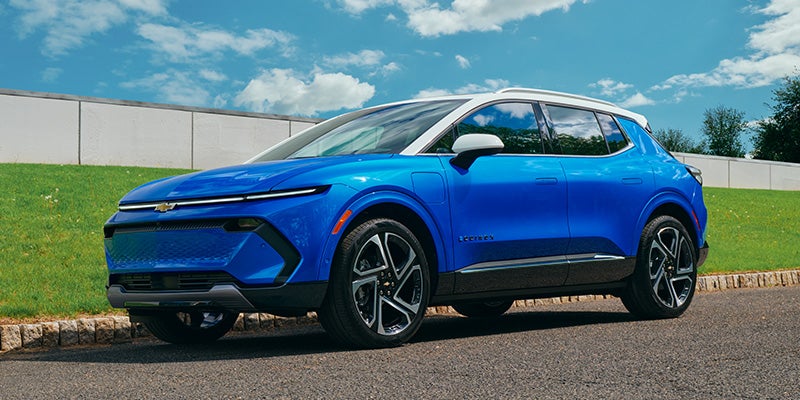 Bright blue electric SUV with a white roof parked on asphalt