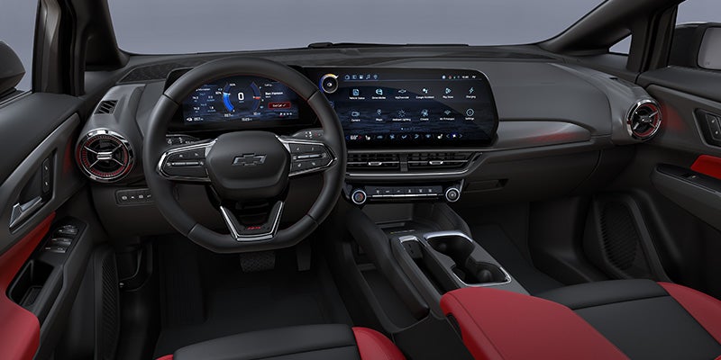 Car interior with black and red seats, a black steering wheel, and dual digital screens for the dashboard and infotainment.