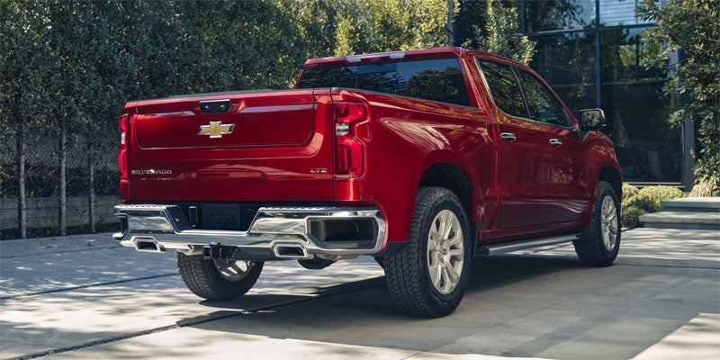 Red Chevrolet Silverado 1500 pickup truck parked outdoors, rear three-quarter view showing the truck bed and cab design