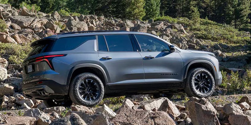 2027 Chevrolet Traverse shown from the rear three-quarter angle on a rugged surface
