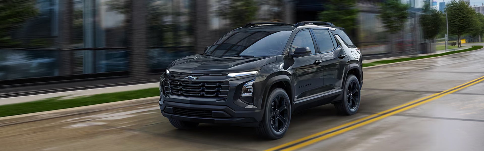 2027 Chevrolet Equinox in red shown from the rear three-quarter on a city street