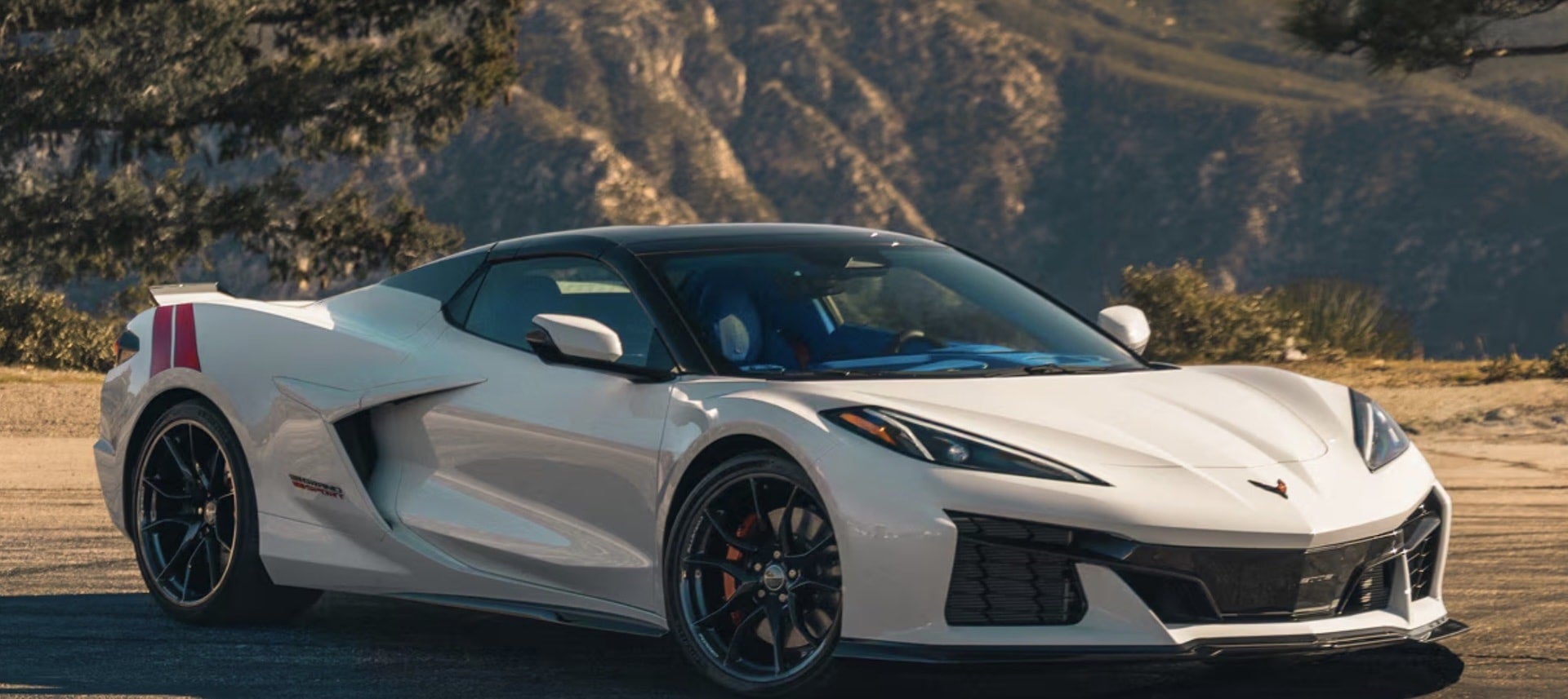 2027 Chevrolet Corvette Grand Sport in white, front three-quarter view in the mountains