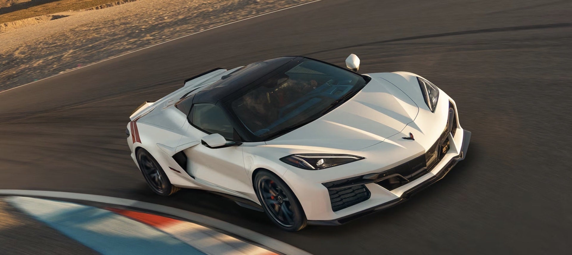 2027 Chevrolet Corvette Grand Sport in white, overhead front three-quarter view on a racetrack