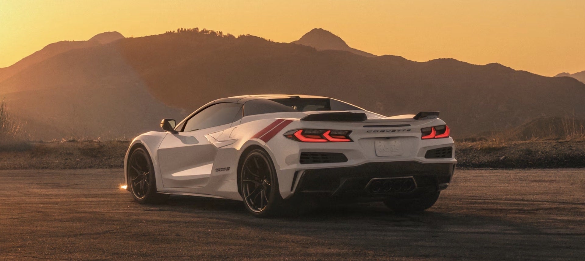 2027 Chevrolet Corvette Grand Sport in white, rear three-quarter view at sunset
