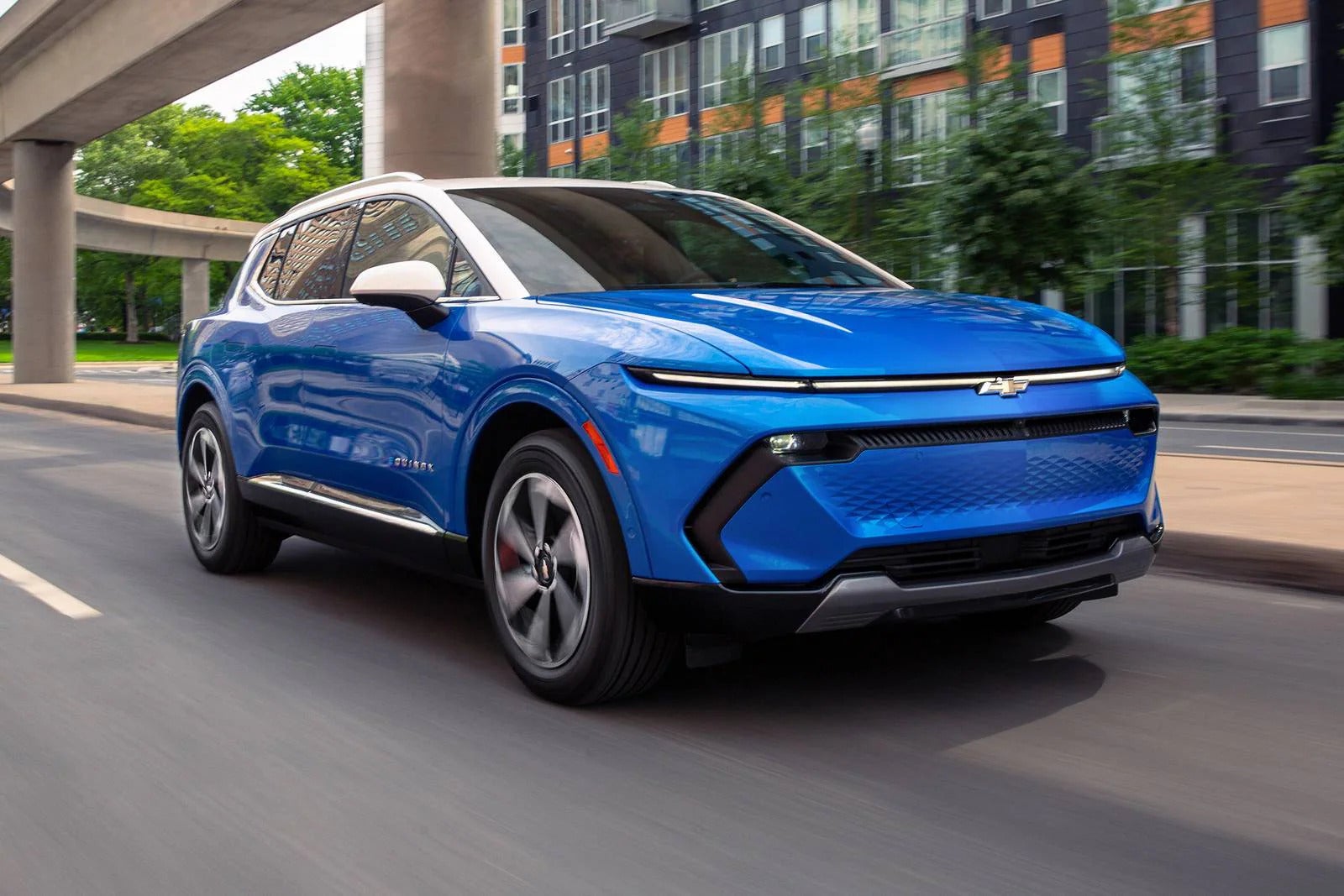 2026 Chevrolet Equinox EV driving ona street in the city